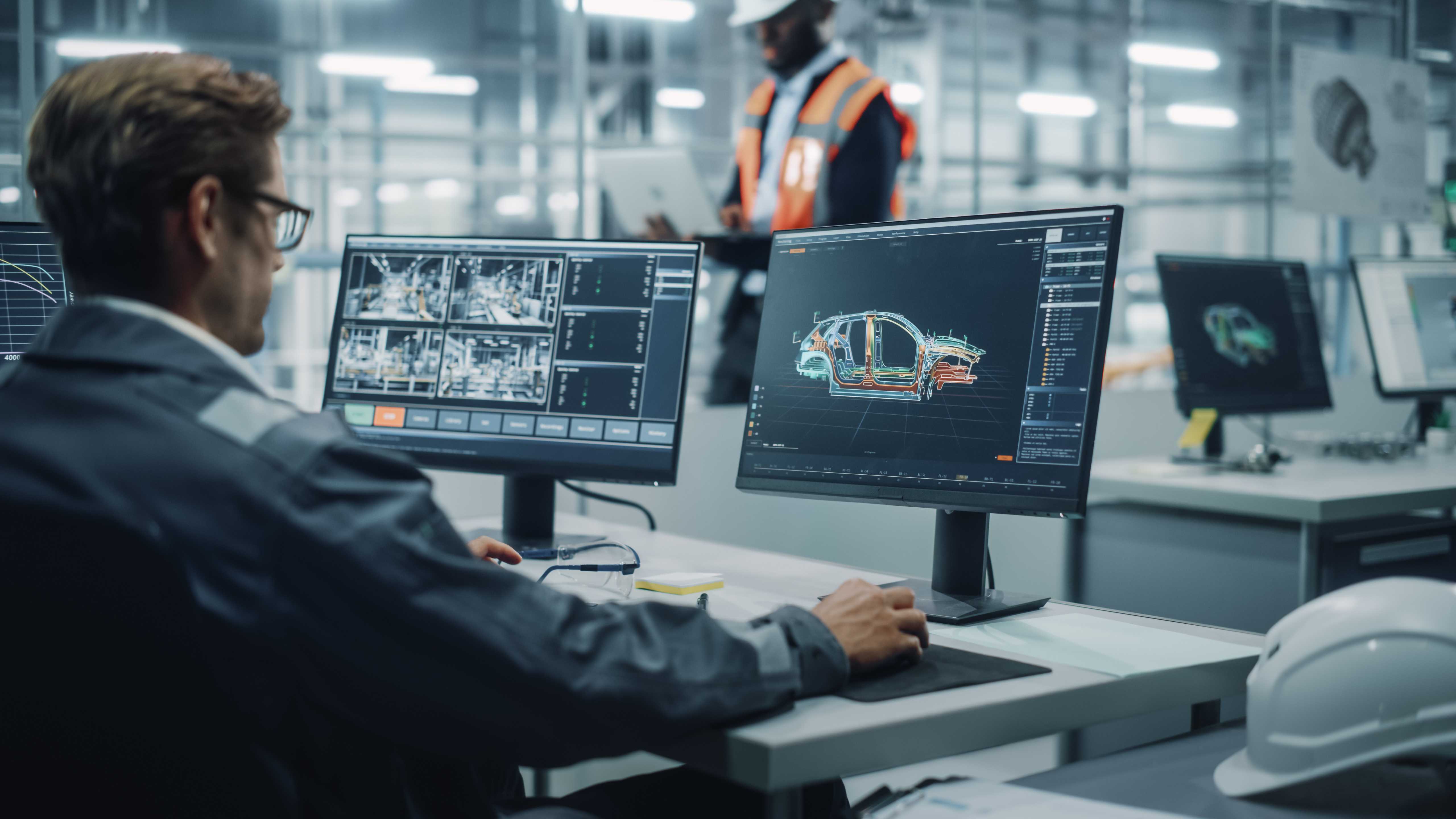 Man in automotive industry working at desk while reviewing electric car production